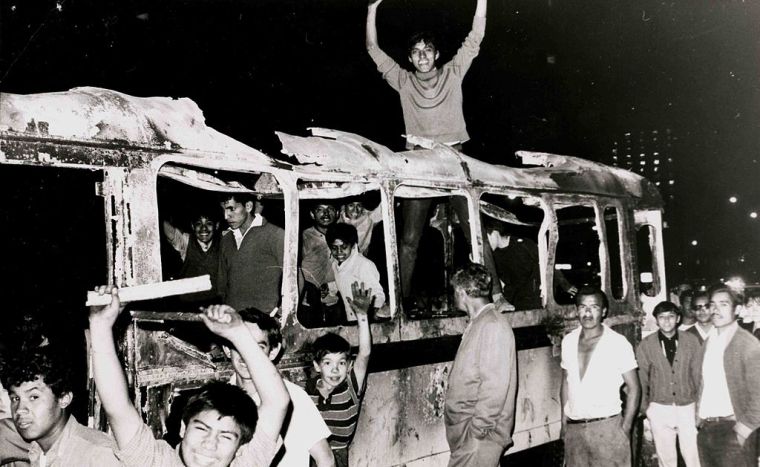 Estudiantes sobre un camión quemado. (Archivo de Marcelino Perelló/Wikipedia)